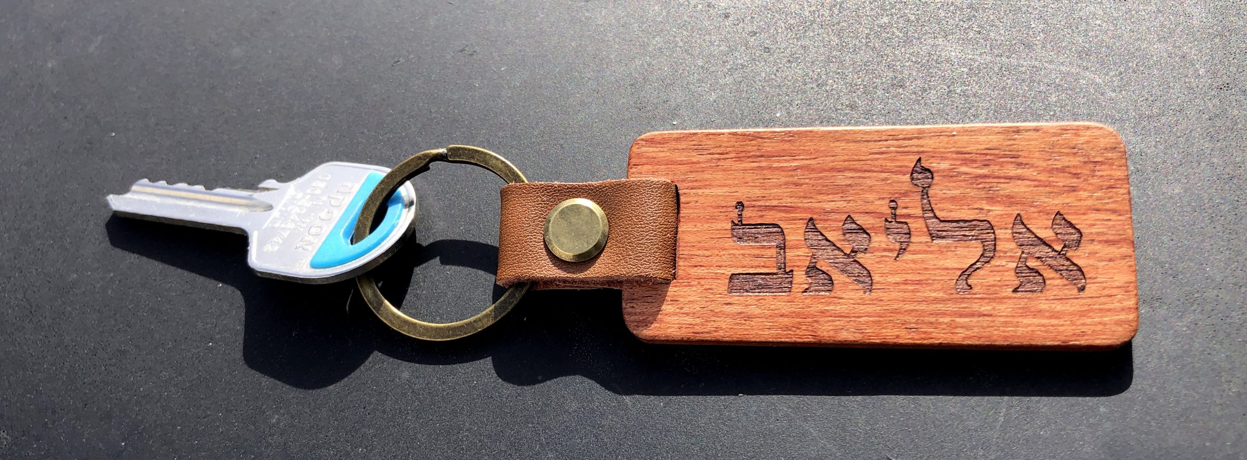 מחזיק מפתחות עץ כהה עם חריטת טקסט אישית ורצועת עור