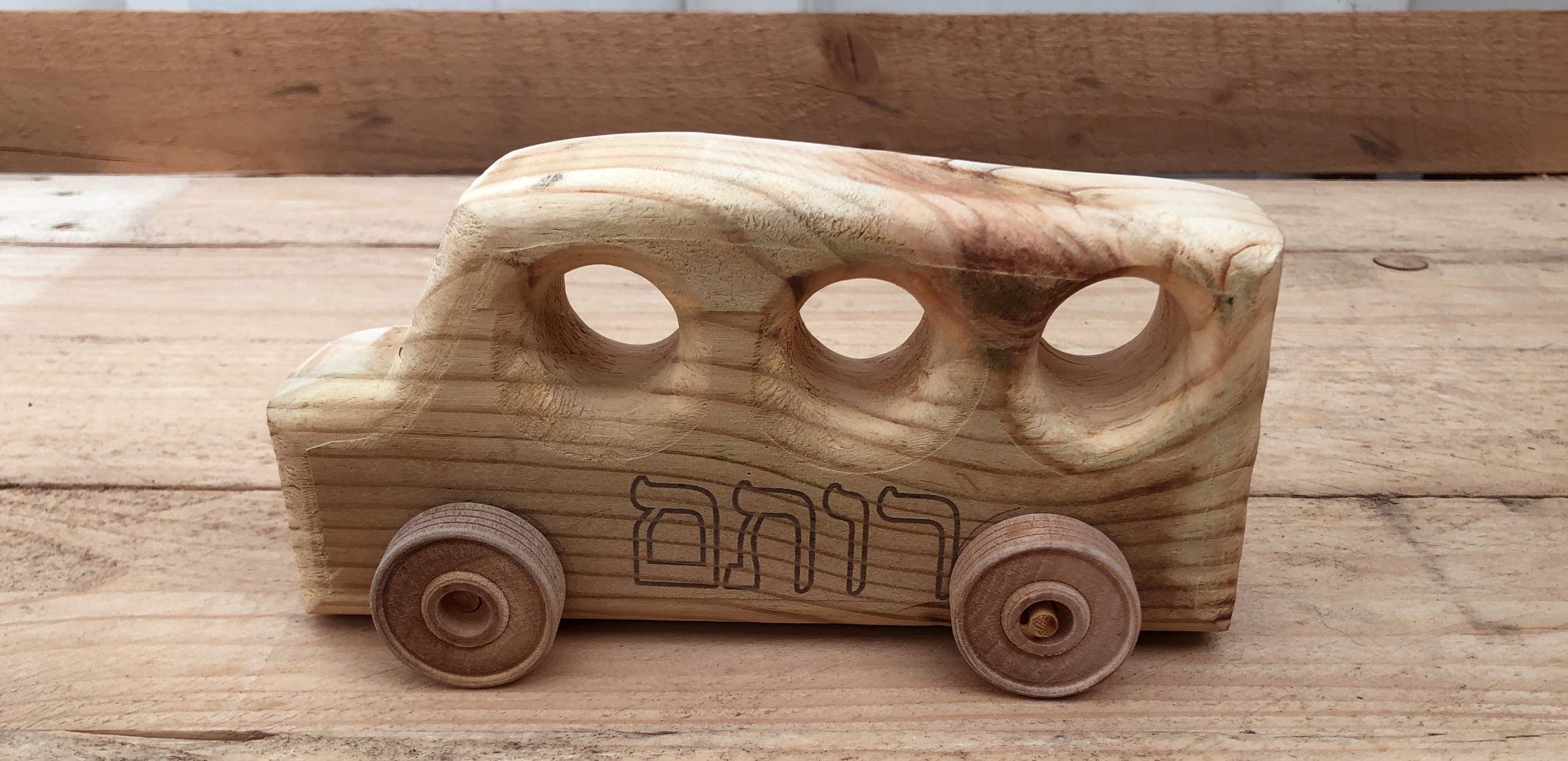 אוטובוס צעצוע מעץ מלא עם גלגלים נעים, עם חריטת שם הילד על גבי העץ